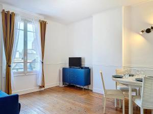 a living room with a table and a blue cabinet at Urban Haven in Deauville