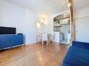 a living room with a table and a blue cabinet at Urban Haven in Deauville