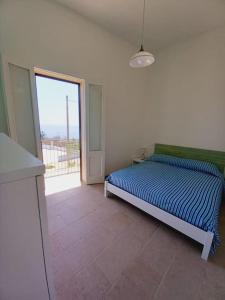 a bedroom with a bed and a large window at Casa Vacanza fronte mare Il Rifugio di Alice in Andrano +9 photos
