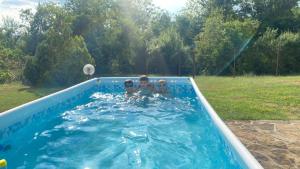 two children playing in a swimming pool at Sichanova Guest House in Brŭchkovtsi