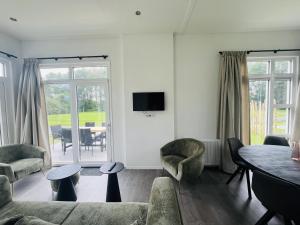 a living room with a couch and a table at Bungalowpark de Horn - Floresta 214 in Dirkshorn