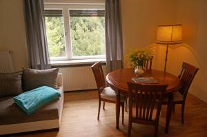 a living room with a table and chairs and a window at Gästehaus Burgenlandschmiede in Meineweh