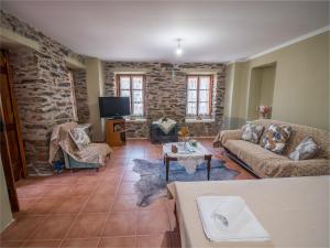 a living room with two couches and a tv at Traditional Stone Villa 1 in Ellinikón