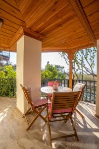 una mesa y sillas en un patio con techo de madera en Villa Marine Hotel, en Akyaka