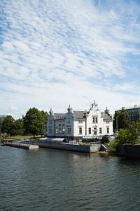 a large white house next to a body of water at Hotel Libava in Liepāja