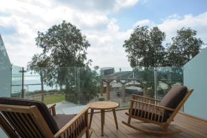 內坦亞的住宿－海灘住宅酒店，阳台配有桌椅,享有建筑的景致。