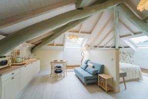 Habitación en el ático con cama y silla azul en Apartamentos Boutique Casa Cigarrán, en Vegadeo