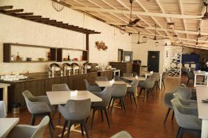 a restaurant with tables and chairs in a room at White Woods Resort, Morjim in Morjim