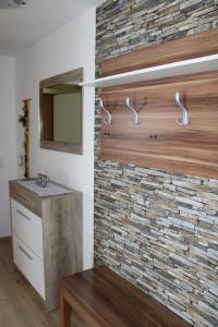 Łazienka z kamienną ścianą i umywalką w obiekcie Ferienwohnung und Gästezimmer Gaspar w mieście Halbenrain
