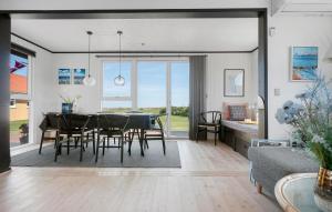 a dining room and living room with a table and chairs at Ocean Front Home In Sæby With Wifi in Sæby