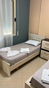 a bedroom with two beds and a window at Amles Apartment in Vlorë