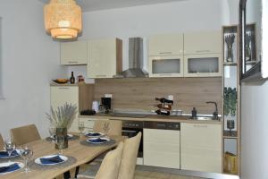 a kitchen with a wooden table and a kitchen with white cabinets at POOl HOUSE BRUNO in Nin