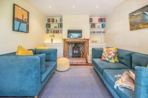een woonkamer met twee blauwe banken en een open haard bij Olive Cottage, Wickham Market in Wickham Market
