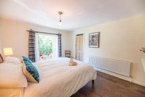 een slaapkamer met een groot wit bed en een raam bij Olive Cottage, Wickham Market in Wickham Market
