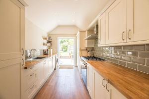 een keuken met witte kasten en een houten vloer bij Olive Cottage, Wickham Market in Wickham Market