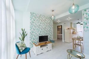 Una sala de estar con televisión, mesa y sillas. en Apartamentos Boutique Casa Cigarrán, en Vegadeo