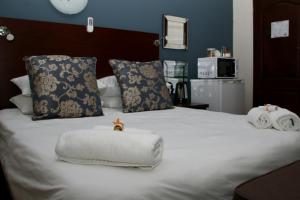 ein Bett mit Handtüchern und einem ausgestopften Tier darauf in der Unterkunft Aalwyns Guesthouse in Vanderbijlpark