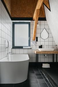 a white bathroom with a tub and a sink at Willa Czaremka - sauna, basen, kino, bilard, bawialnia in Ujsoły