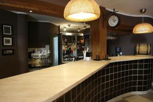 a bar with a counter with a clock on the wall at Hotel Sunny in Poznań