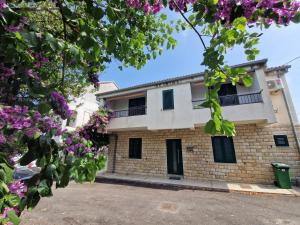 a building with purple flowers in front of it at Holiday Home Marija in Biograd na Moru