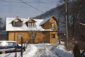 a large wooden house with snow on the roof at Guesthouse U dida Viktora in Yaremche