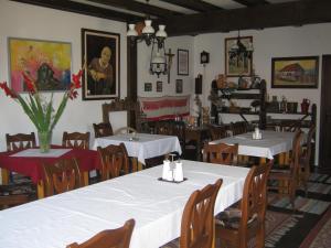 a dining room with tables and chairs with white table cloth at Zárug Vendégház in Lăzarea