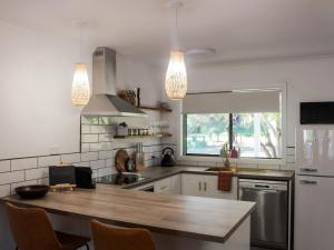 a kitchen with a wooden counter top and two lights at Buchan Motel in Buchan