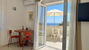 a room with a table and chairs and an umbrella at Lukenda Rooms - Boutique Apartments with view of Adriatic Sea in Pakoštane
