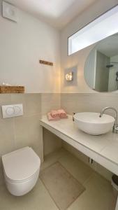 a bathroom with a sink and a toilet and a mirror at Lukenda Rooms - Boutique Apartments with view of Adriatic Sea in Pakoštane