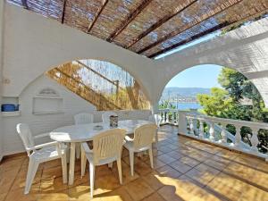 a dining room with a table and chairs on a balcony at Poros Pine View in Poros