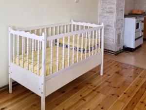 a white crib in a room with a kitchen at Apartments center Zorić in Žabljak
