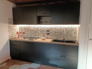 a kitchen with black cabinets and a sink at Capocampo Amalfi Coast in Tramonti