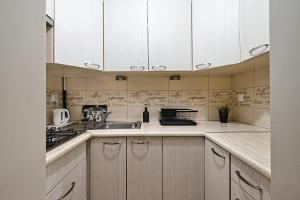 a kitchen with white cabinets and a sink at UrbanNest - Cozy studio - Bagno 7 in Warsaw +5 photos