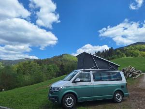a green van with its roof up on a hill at Wildnis- und Offroad Camp Schwarzwald in Bad Peterstal-Griesbach
