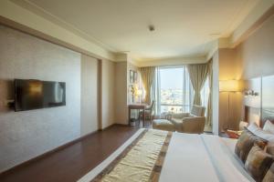 a hotel room with a large bed and a television at Vesta International in Jaipur