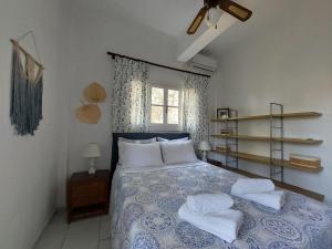 a bedroom with a blue and white bed with two pillows at Poros Pine View in Poros