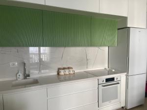 a kitchen with white appliances and green cabinets at Apartament REJ VELIPOJE in Velipojë +16 photos