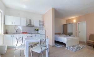 a kitchen and a living room with a table and chairs at Studio apartman Bella in Selca