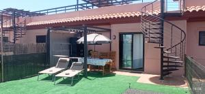 a patio with a table and chairs on a house at La casita de Taty in Majanicho