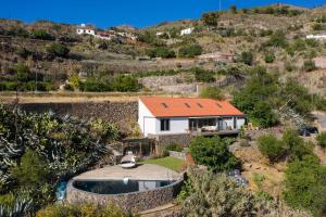 una casa con techo naranja en una colina en Finca en el Corazón de la Isla, en Tejeda