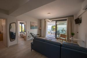 a living room with a blue couch and a balcony at Casa de Lapel Mola Kaliva in Mola Kalyva