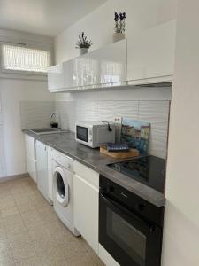 a kitchen with a washer and dryer on a counter at CASSIS RDC Climatisé - Parking gratuit in Cassis