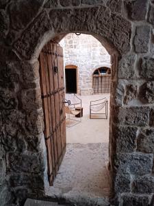 マルディンにあるBeyt Merin Konağıの背景に椅子がある石造りの建物のアーチ道