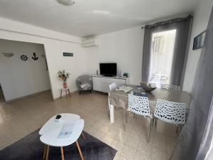 a living room with a table and chairs at CASSIS RDC Climatisé - Parking gratuit in Cassis