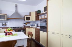 a kitchen with a table with a bowl of fruit on it at La Foglia Verde - B&B Affittacamere in Pesaro