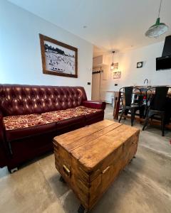 ein Wohnzimmer mit einer Ledercouch und einem Tisch in der Unterkunft Alojamientos Rías Baixas - Mares del Forte- Cangas in Cangas