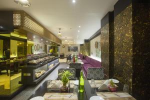 a dining room with tables and chairs in a restaurant at Vesta Maurya Palace in Jaipur
