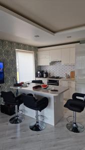 Una cocina con sillas negras y una encimera blanca. en MC apartments, en Rēzekne