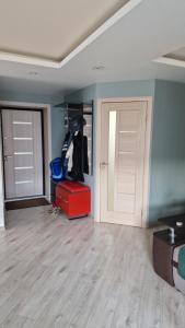 una habitación con dos puertas y una maleta roja en MC apartments, en Rēzekne