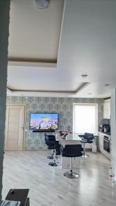 Una habitación con una mesa y sillas y un televisor. en MC apartments, en Rēzekne 1 foto más